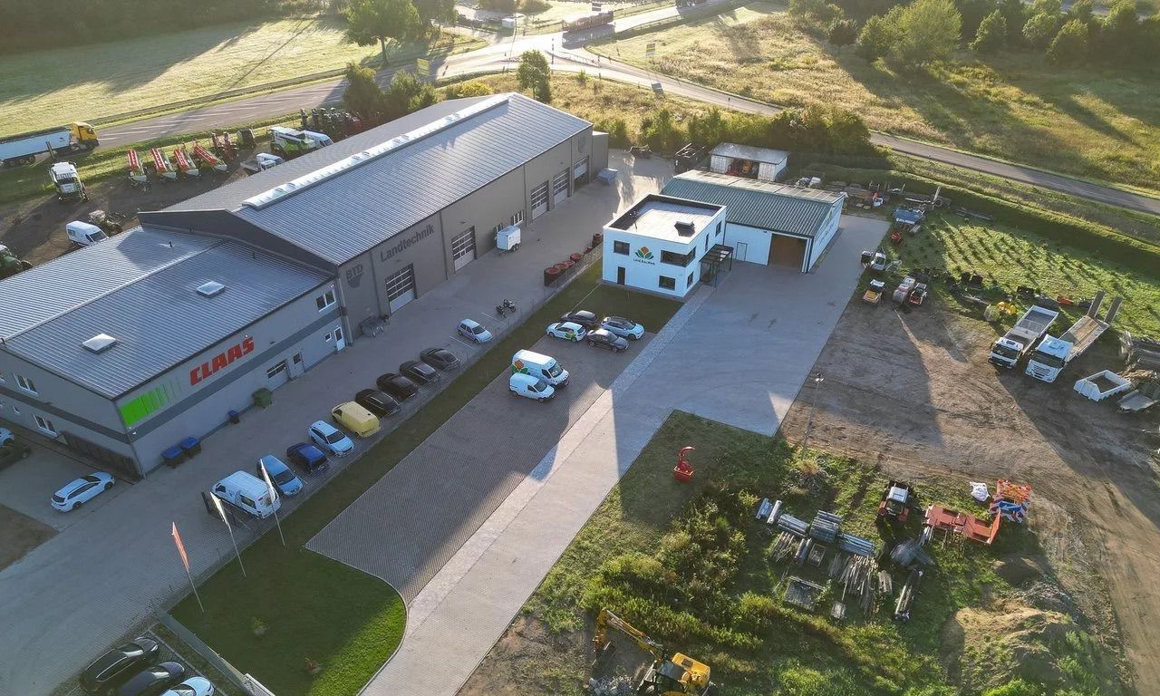 Luftbild des Betriebshofs von Land.Bau.Werk in Perleberg: Halle, Verwaltungsgebäude, Fuhrpark und Lagerflächen